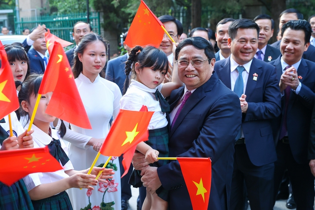 PM Pham Minh Chinh meets Vietnamese expats in Beijing - Ảnh 1.