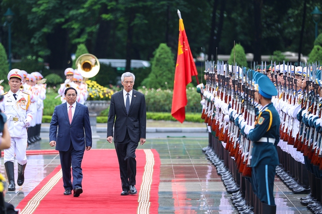 Photos: Vietnamese Prime Minister hosts official welcome ceremony for Singaporean counterpart - Ảnh 3.