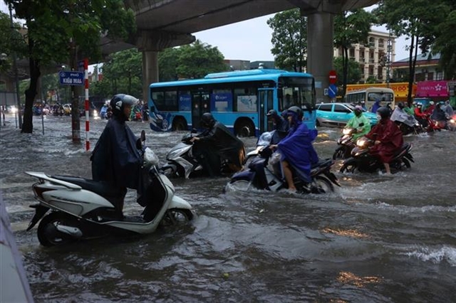Heavy downpours leave Ha Noi's low-lying streets under water- Ảnh 2.