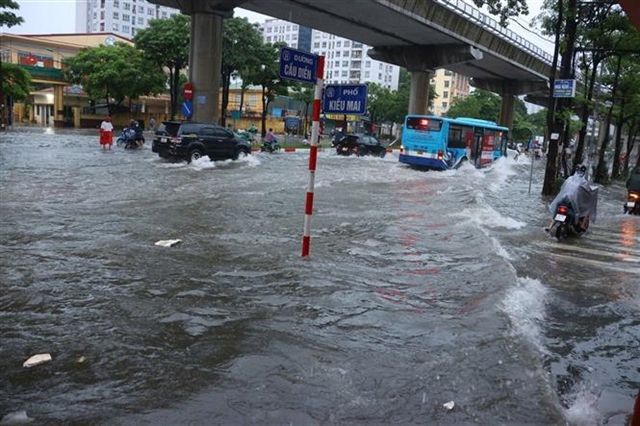 Heavy downpours leave Ha Noi's low-lying streets under water- Ảnh 3.