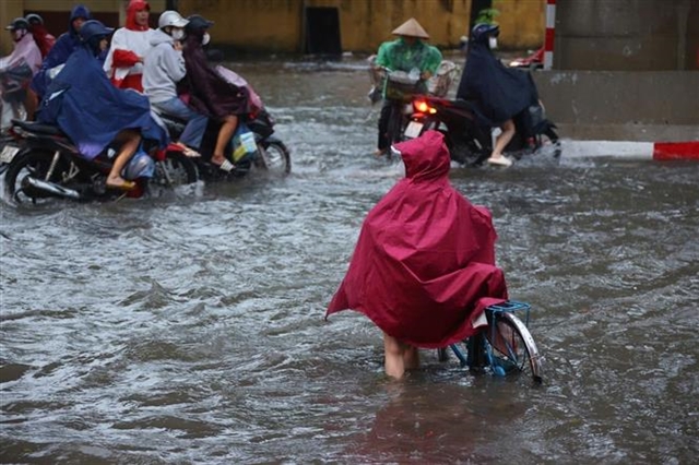 Heavy downpours leave Ha Noi's low-lying streets under water- Ảnh 4.