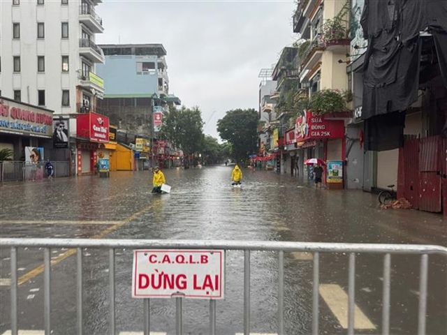 Heavy downpours leave Ha Noi's low-lying streets under water- Ảnh 5.