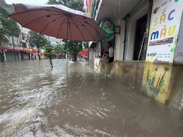 Heavy downpours leave Ha Noi's low-lying streets under water- Ảnh 6.