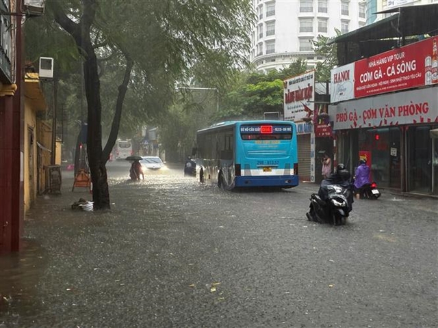 Heavy downpours leave Ha Noi's low-lying streets under water- Ảnh 7.