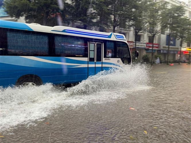Heavy downpours leave Ha Noi's low-lying streets under water- Ảnh 8.