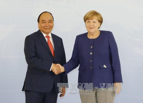 Thủ tướng Nguyễn Xuân Phúc (trái) bắt tay Thủ tướng Angela Merkel. Ảnh: TTXVN.