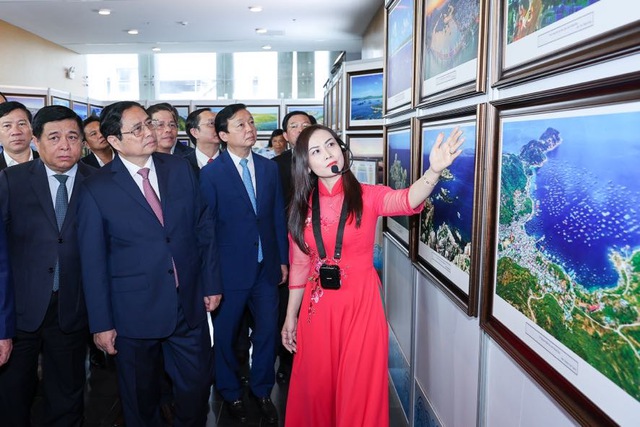 Thủ tướng và các đại biểu nghe giới thiệu Triển lãm ảnh Bắc Trung Bộ và Duyên hải Trung Bộ 
